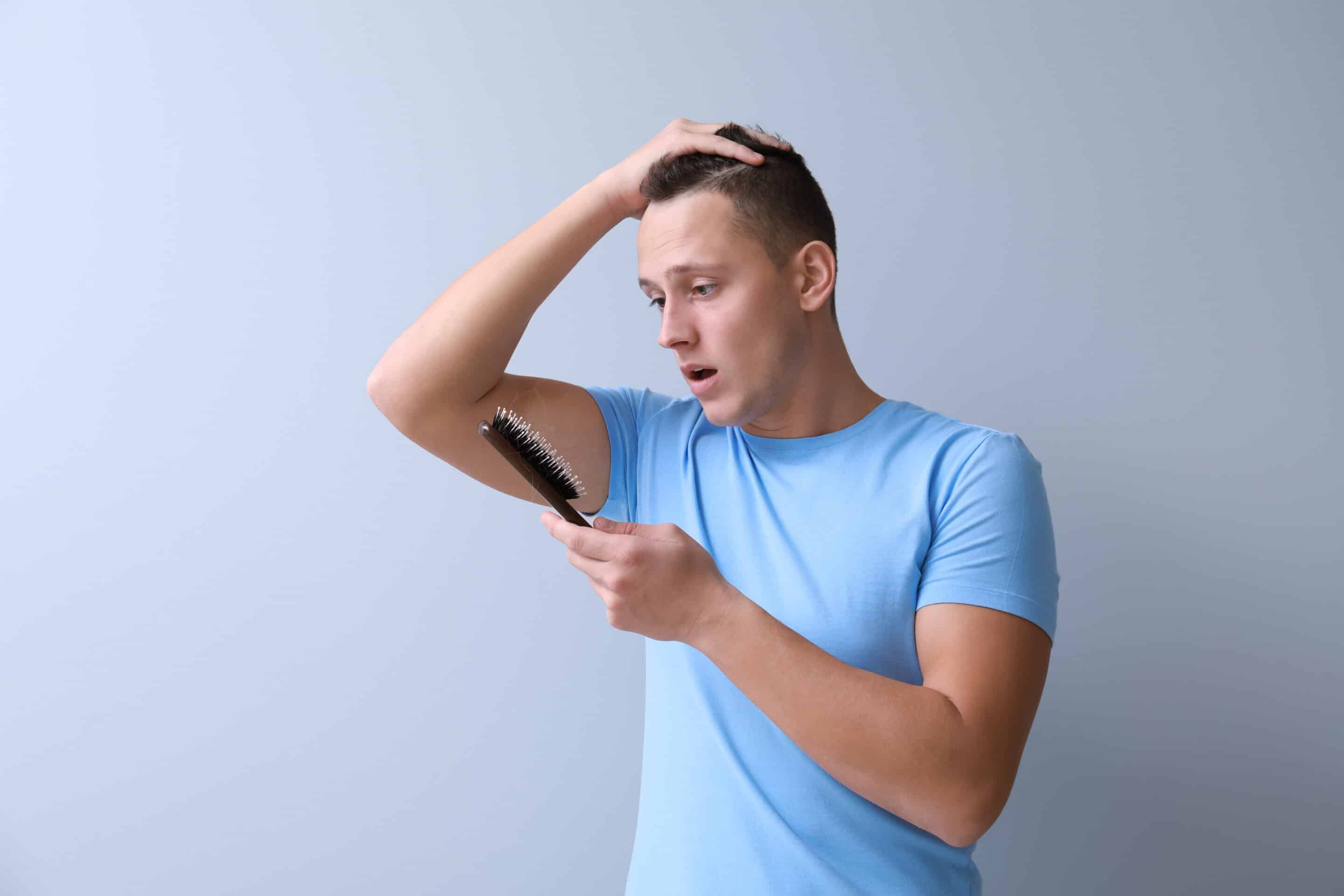 Ein Mann, der nach seiner Haartransplantation feststellt, dass Haare ausfallen
